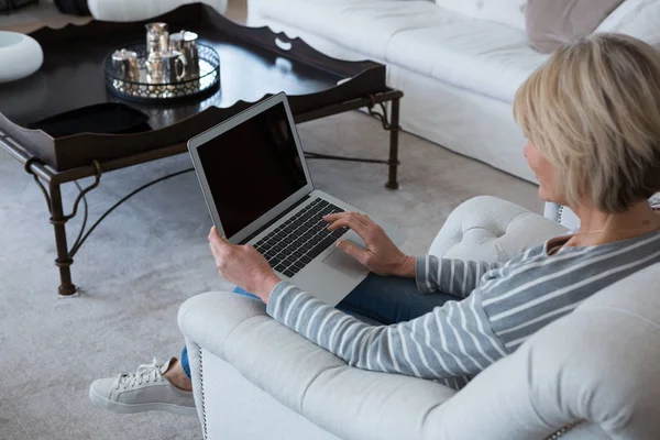 Vrouw met laptop in de woonkamer — Stockfoto