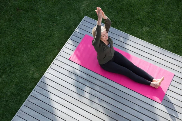 Frau praktiziert Yoga auf Veranda — Stockfoto