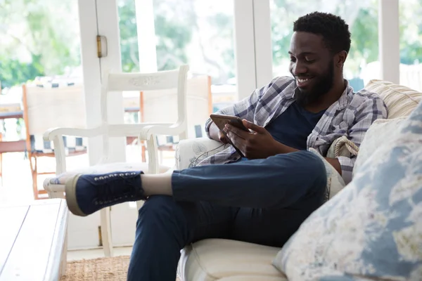 Homem usando tablet digital na sala de estar — Fotografia de Stock