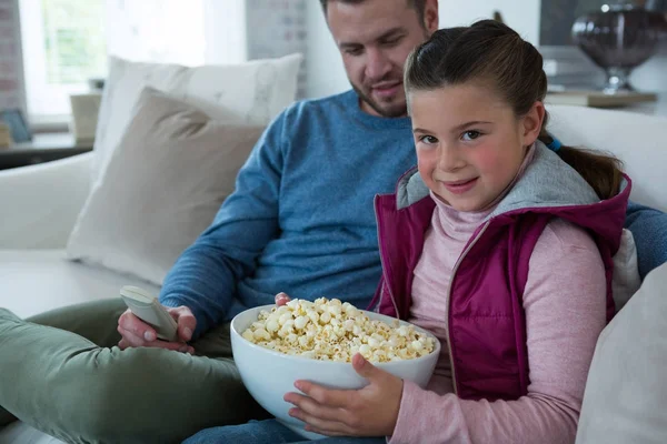 Cute girl holding bowl full of popcorn — Stock Photo, Image