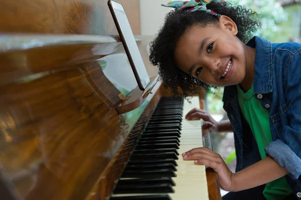 Flicka spela piano med digital tablett — Stockfoto