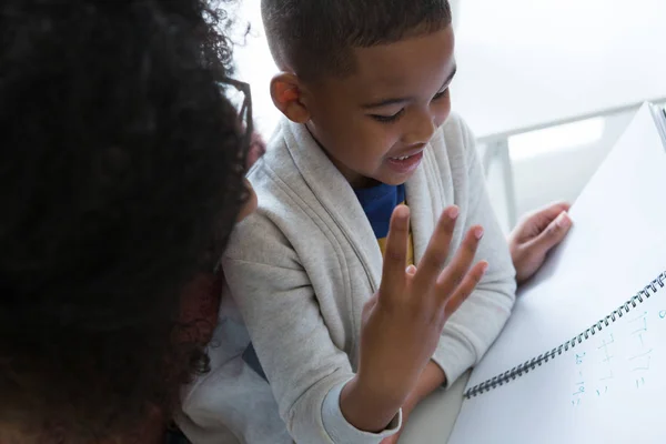 Mère aidant son fils dans ses études — Photo