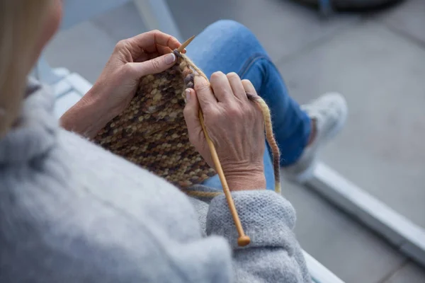 Vrouw breien wol in portiek — Stockfoto