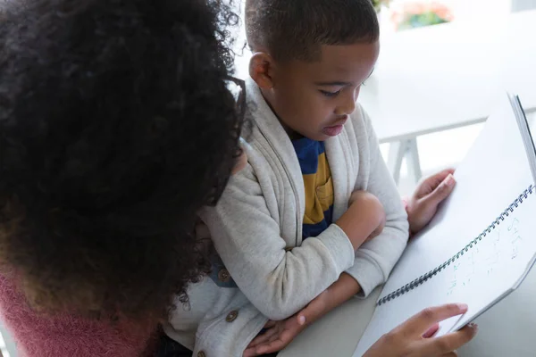 Mère aidant son fils dans ses études — Photo