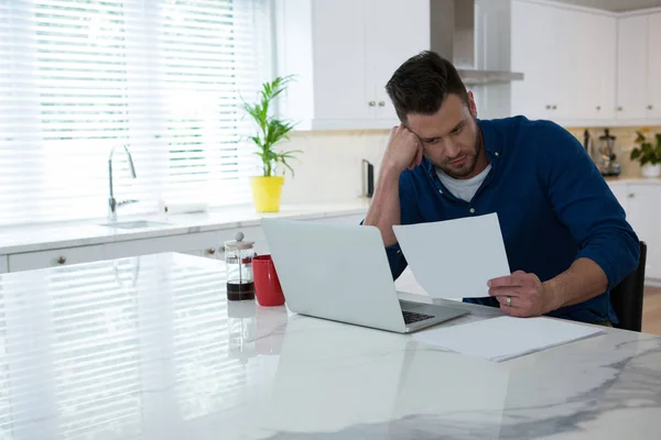 Man looking at bill in kitchen — Stock Photo, Image