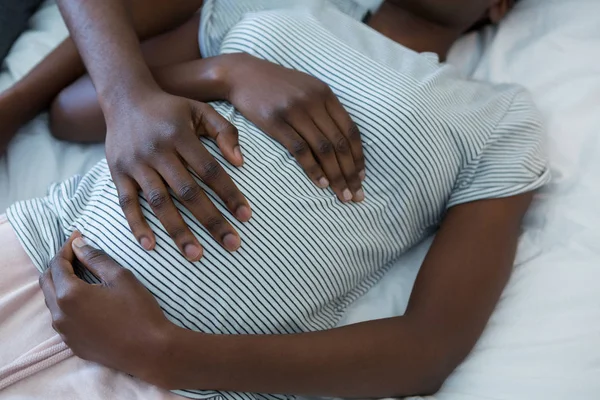 Man touching woman stomach while sleeping — Stock Photo, Image