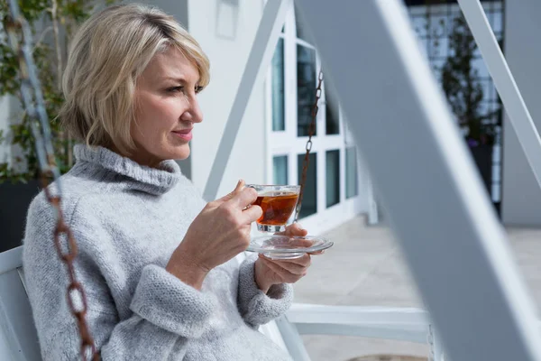 Mujer tomando té de limón en el porche — Foto de Stock