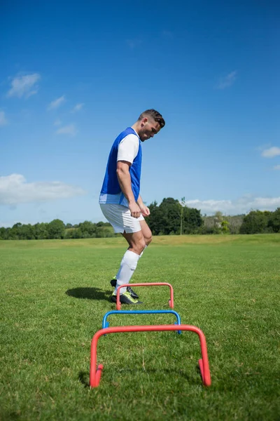 Jugador de fútbol practicando en obstáculo — Foto de Stock