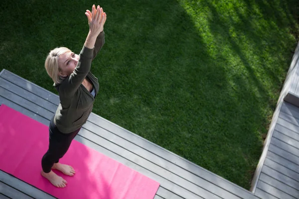 Frau praktiziert Yoga auf Veranda — Stockfoto