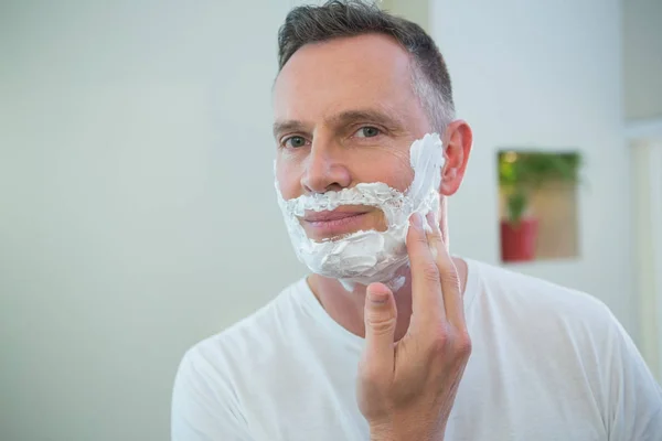 Άνθρωπος εφαρμογή αφρό ξυρίσματος στο πρόσωπο — Φωτογραφία Αρχείου