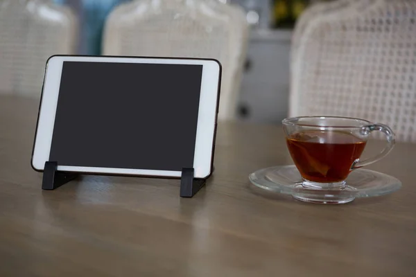 Tablet and lemon tea on dining table — Stock Photo, Image