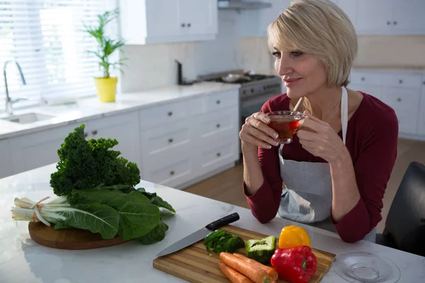 Mujer tomando té de limón en la mesa — Foto de Stock