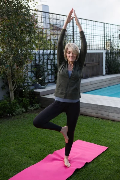 Frau praktiziert Yoga im Rasen — Stockfoto