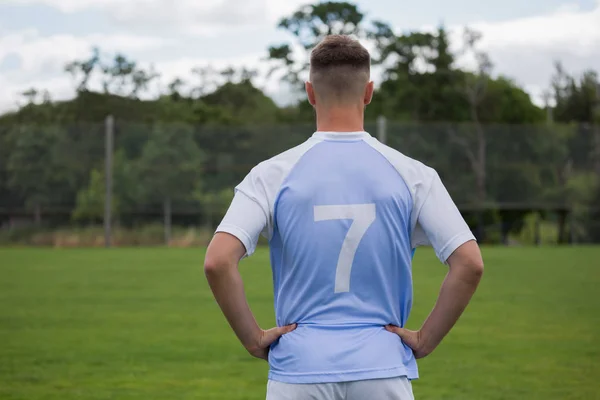 Jogador de futebol de pé com a mão nos quadris — Fotografia de Stock