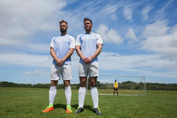 Jugadores de fútbol de pie en el suelo — Foto de Stock