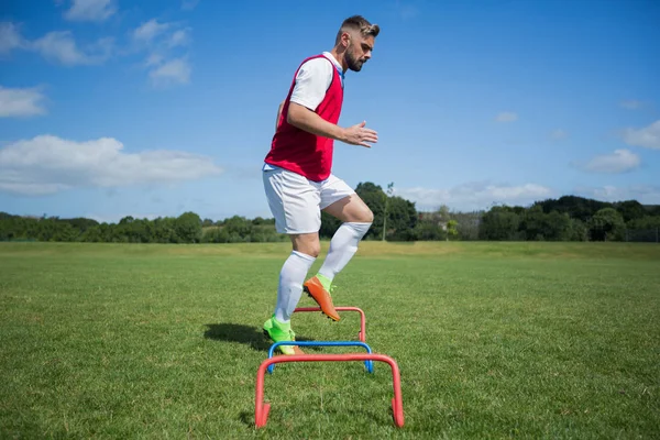 Fotbalista cvičení na překážku — Stock fotografie