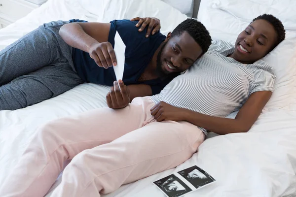 Man en zwangere vrouw kijken naar echografie — Stockfoto