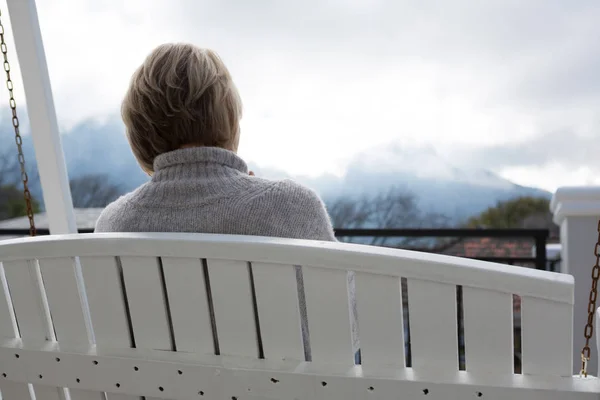 Doordachte vrouw ontspannen in portiek — Stockfoto