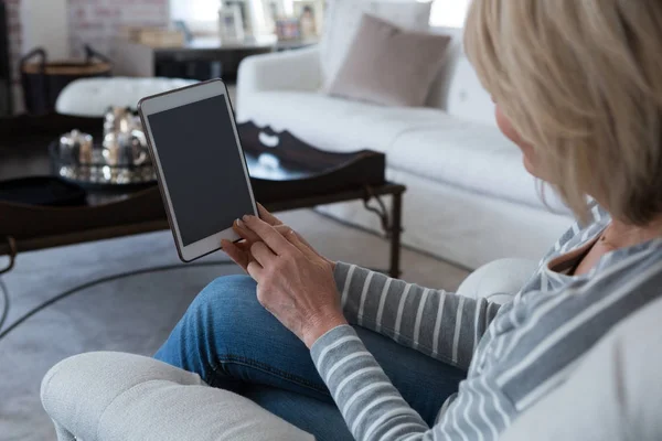 Woman using digital tablet in living room — Stock Photo, Image