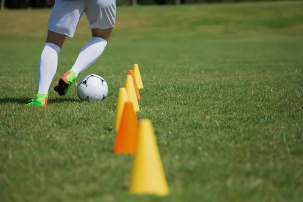 Jogador de futebol driblando através de cones — Fotografia de Stock