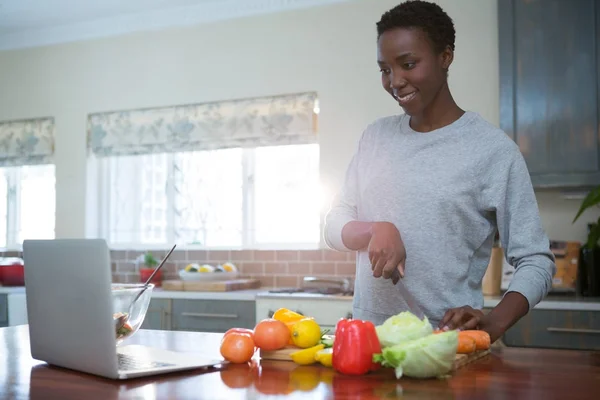 Mujer aprendiendo receta de comida de portátil — Foto de Stock