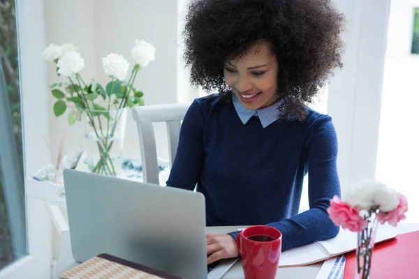 Hermosa mujer usando portátil en el escritorio — Foto de Stock