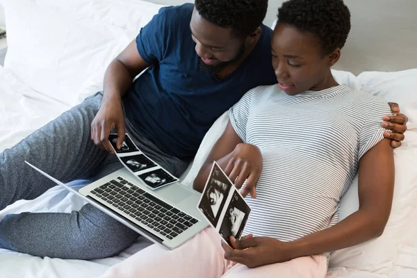 Мужчина и беременная женщина смотрят на сонографию — стоковое фото