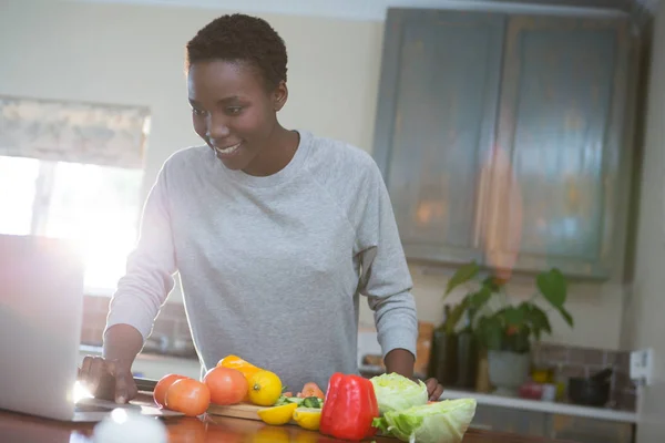Mujer aprendiendo receta de comida de portátil —  Fotos de Stock
