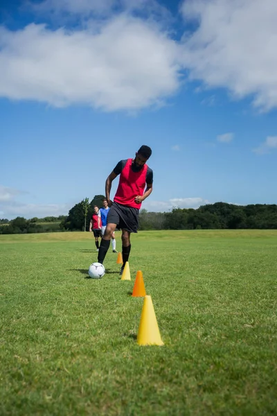 Jugador de fútbol driblando a través de conos — Foto de Stock