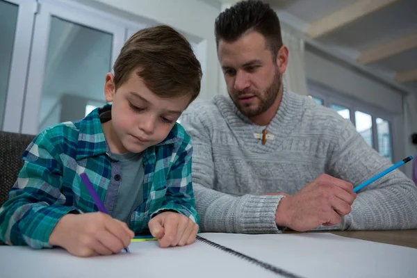 Father assisting son in his studies — Stock Photo, Image