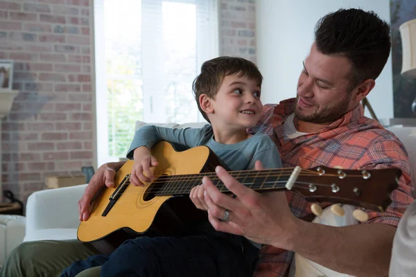 Father assisting his son in playing guitar — Stock Photo, Image