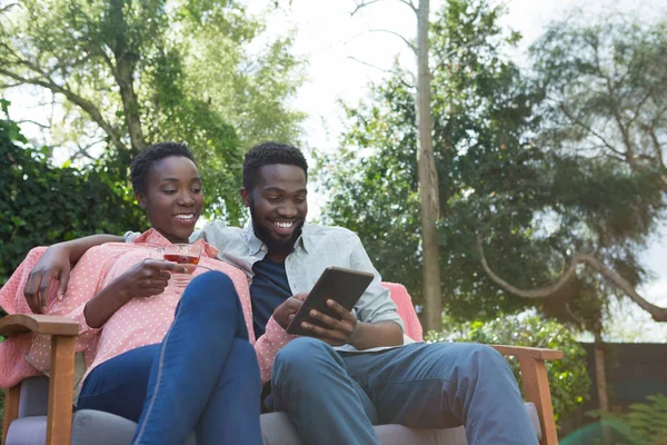 Pasangan yang menggunakan tablet digital di kebun — Stok Foto
