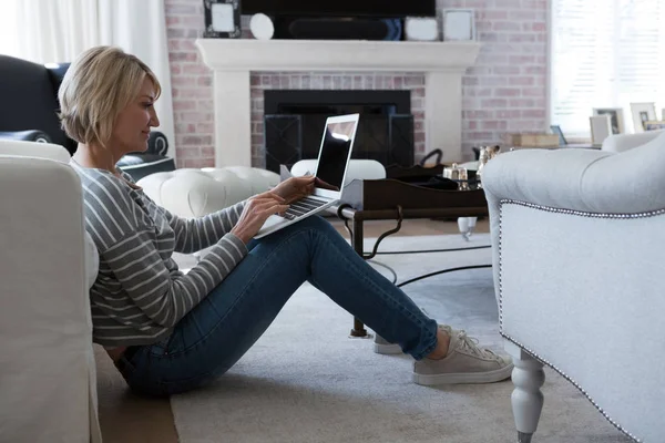 Vrouw met laptop in de woonkamer — Stockfoto