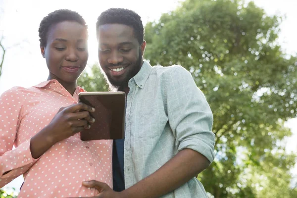 Ehepaar nutzt digitales Tablet im Park — Stockfoto