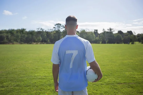 Jogador de futebol segurando futebol — Fotografia de Stock