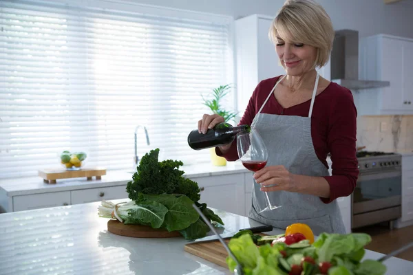 Belle femme ayant du vin rouge à table — Photo