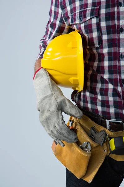 Architect with tool belt and holding hard hat — Stock Photo, Image