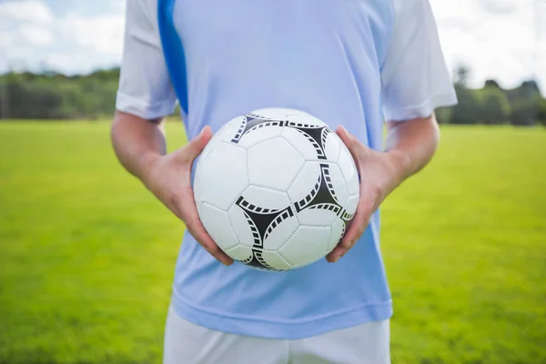 Jogador de futebol segurando futebol — Fotografia de Stock