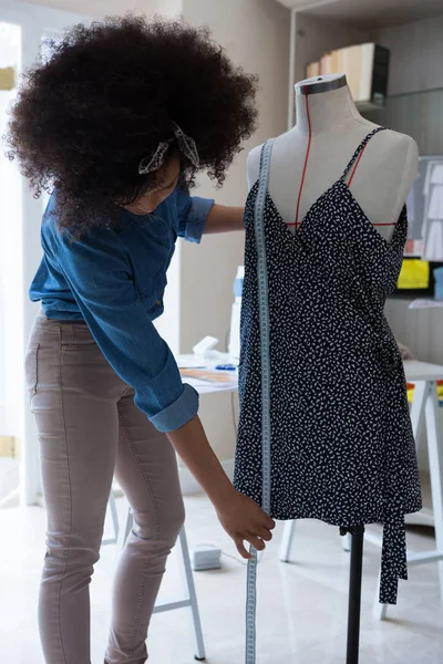 Vrouwelijke ontwerper lengtemeting van jurk — Stockfoto