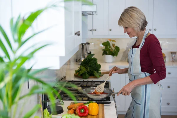 Kvinna matlagning mat i köket — Stockfoto