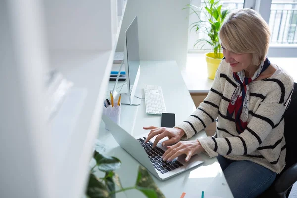 Жінка використовує ноутбук за столом — стокове фото