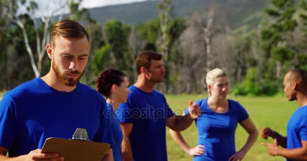 Hombre de pie y sosteniendo un portapapeles — Vídeos de Stock