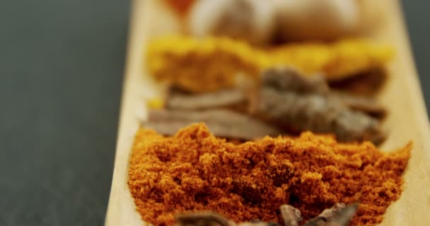 Olika kryddor på träbricka — Stockvideo