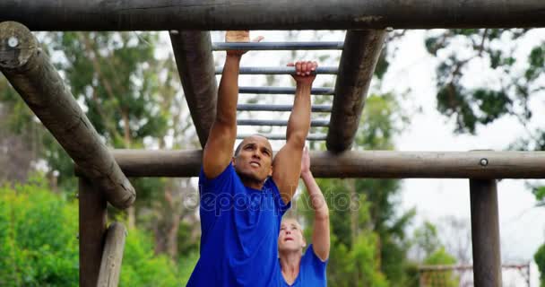 Fit man klimmen monkey bars — Stockvideo