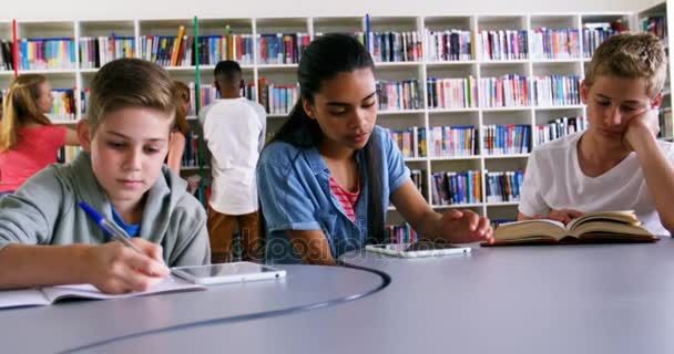 Школьники, обучающиеся в библиотеке — стоковое видео