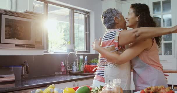 Madre e hija abrazándose en la cocina — Vídeo de stock