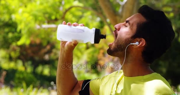 男性慢跑的饮用水从瓶子在公园4K — 图库视频影像