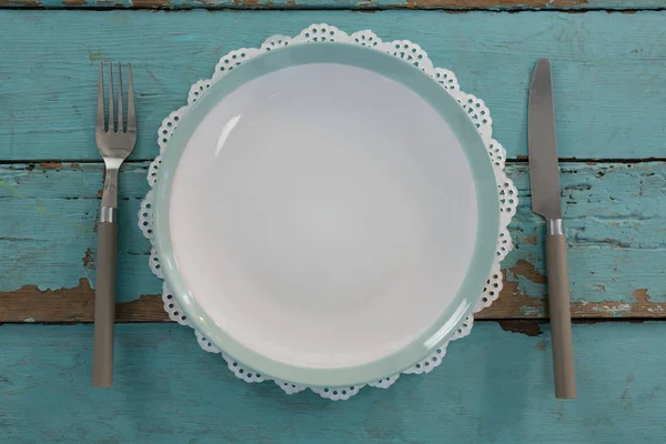 Placa con tenedor y cuchillo de mantequilla en la mesa —  Fotos de Stock