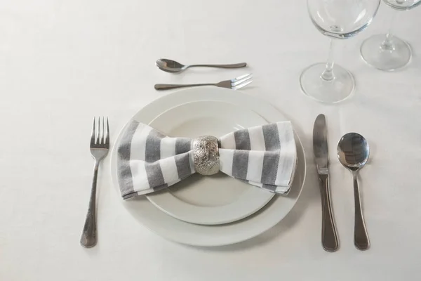 Prato e talheres ajustados elegantemente em uma mesa — Fotografia de Stock