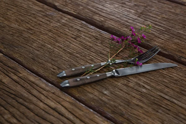 Cuchillo tenedor y mantequilla con flor en la mesa — Foto de Stock